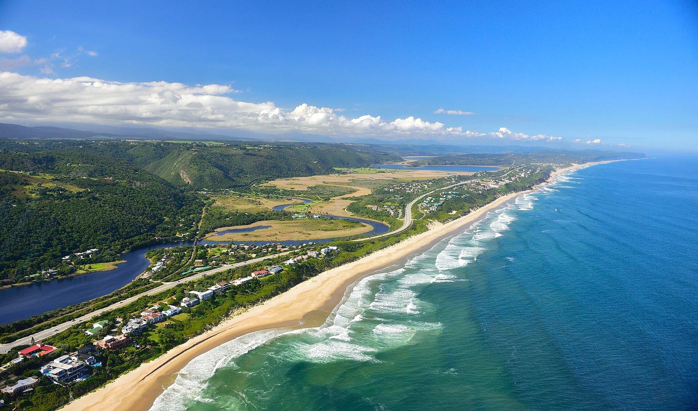 Luftaufnahme von Wilderness: langer Sandstrand, Lagune, Seen und die N2 zwischen Küste und bewaldeten Hügeln
